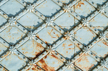 Wall Mural - Vintage metal brown surface with rusty architectural details in form of flowers, closeup of metal texture fragment of old metal gates