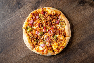 Wall Mural - Delicious pizza topped with melted cheese, tender beef, mushrooms, pickles, and onions, sitting on a wooden surface. Ideal for food-related projects and culinary themes.