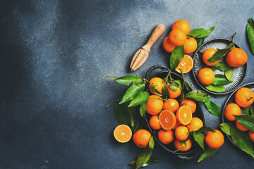 Wall Mural - Fresh tangerines with green leaves on a metal plate. Composition of mandarin fruits.