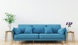 © PERFECTisME - A light blue sofa with four pillows sits in front of a white wall with a plant and flowers on side tables