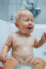 Wall Mural - Bathing a baby at home in the bathroom. Personal hygiene of the baby. Care for the baby's skin.