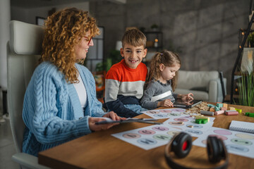 woman speech teacher with boy and girl on private lesson at home