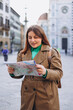© mdyn - Happy 30s young woman with map in old town in Florence. Holidays and tourism concept. Female tourist searching direction on location map outdoors. Stylish woman visiting Italian landmarks
