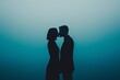 © nuttapong - Silhouette of a couple sharing a romantic moment in a soft blue haze.