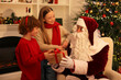 © New Africa - Christmas celebration. Santa Claus giving gift box to kids at home