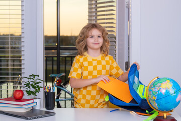 Fototapete - Preparation for school. Nerd school kid doing homework at home. Clever child from elementary school with book. Smart genius intelligence kid ready to learn. Hard study.