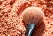 © Iremia - A close-up shot of a powder makeup brush with a glossy black handle and a soft, fibrous bristle head