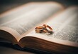 © Alexandra - Wedding rings placed on an open book represent the sacred union of marriage within a religious context