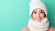 © Mary_AMM - Studio portrait of cheerful young woman wearing warm winter clothes and smiling on turquoise background