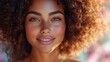 © Prostock-studio - A woman with curly hair and freckles smiles warmly, highlighting her natural beauty against a vibrant, colorful background in bright daylight.