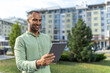© zinkevych - Businessman with tablet standing near buildings checking built project
