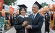 © RooftopStudioBangkok - proud graduate poses with her father, holding her diploma at graduation ceremony. festive atmosphere is filled with family and friends celebrating this milestone