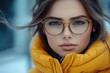 © Ева Поликарпова - A woman wearing glasses and a yellow jacket