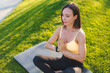 © Strelciuc - A woman is practicing yoga and meditation outdoors on a mat in a beautiful natural setting