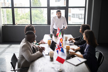 Leinwandbilder - Diverse professionals engage in a collaborative meeting around a conference table, discussing strategies and ideas.