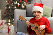 © Pixel-Shot - Cute little boy in Santa hat playing guitar at home on Christmas eve