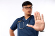 © ArvStd - Healthcare workers concept. Serious-looking displeased asian doctor, nurse in scrubs stopping you, show prohibit, warning gesture, forbid patient