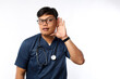 © ArvStd - Young asian nurse man isolated on white background listening to something by putting hand on the ear