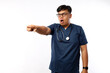 © ArvStd - Young asian man wearing doctor uniform and stethoscope pointing with finger surprised, open mouth amazed expression, something on the front