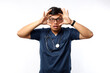 © ArvStd - Young asian doctor man over isolated background.Trying to open eyes with fingers, sleepy and tired for morning fatigue
