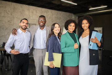 Leinwandbilder - A group of diverse professionals gathers in a contemporary office, sharing ideas and documents. Their teamwork symbolizes cooperation and success in their careers.