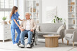 © Pixel-Shot - Female doctor with mature man in wheelchair at home
