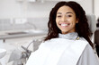 © Prostock-studio - Stomatologic Treatment. Portrait Of Smiling African American Woman Sitting In Dentists Chair In Clinic, Cheerful Young Black Female Patient Waiting For Check Up With Orthodont, Looking At Camera