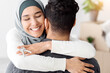 © Prostock-studio - Happy young lady in hijab with keychain hugging her husband and smiling, copy space. Cheerful muslim family celebrating moving to their house, smiling and embracing. Relocation, moving concept