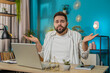 © Andrii Iemelianenko - I don't know what to say. Confused young Caucasian man feeling embarrassed about ambiguous question, having doubts, no idea, being clueless and uncertain. Guy at home office table workplace. Lifestyle