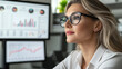 © stock1 - A strong female boss conducting a hybrid strategy session, digital charts visible on screens