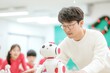 © Ryzhkov - Innovative Education Teacher and Students Explore Robotics in Festive Classroom Setting