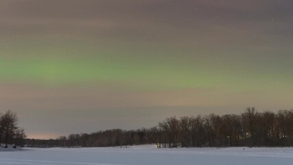 Wall Mural - Geomagnetic storm also known as The Northern Lights dances over a frozen lake in Wisconsin, USA during winter nighttime.
