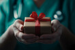 © Pukan - A healthcare professional presents a small gift wrapped in brown paper with a red ribbon, symbolizing care and kindness.