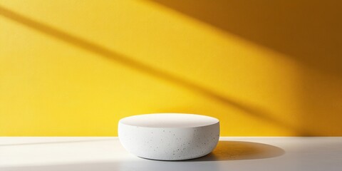 Poster - A minimalistic white bowl on a white surface against a vibrant yellow wall, showcasing simplicity.