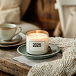 © AImagine Designs - 2025 vintage candle concept. A cozy candle with a year label, set on a rustic table with a cup