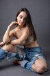 © Mountains Hunter - A beautiful brunette poses in the studio wearing a top and jeans.