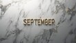 © Andrew - Golden September on Marble: Elegant gold lettering spelling out 'September' rests on a sophisticated marble background.