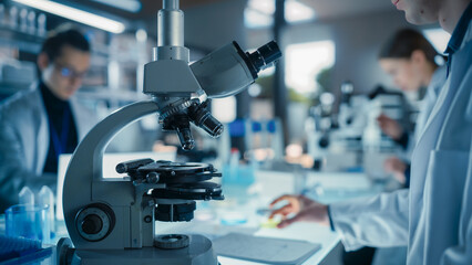 Aufkleber - Close Up Portrait of a Young Microbiologist Wearing Glasses and Looking Through the Microscope, Analyzing Sample Cells. Cheerful Scientist Working in a Medical Science Laboratory