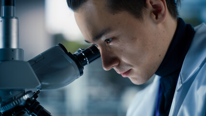 Aufkleber - Portrait of a Handsome Chemistry Student Working on a Research Project in University. Medical Research Scientist Looking at Biological Samples Under a Microscope in an Applied Science Laboratory