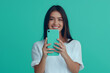 © Rattanapon - Isolated shot of smiling woman holds modern mobile phone, isolated on blue background.