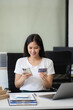 © NINENII - Female asian use credit cards to conduct financial transactions through phones, tablet at home office.