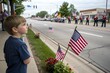 © Ripa Roy - A young boy, eyes wide with wonder, watches a Memorial Day parade. Flags wave, bands play, and soldiers march, filling the air with pride and patriotic spirit.