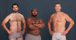 © peopleimages.com - Portrait, body positivity and confident men in underwear with support, inclusion and unique identity in studio. Diversity, solidarity and male friends with pride, arms crossed and grey background