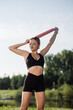 © rostyslav84 - Beautiful girl in sportswear doing exercises with a rubber band in the park on a sunny day