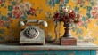 © Helois - Vintage rotary phone and dried flowers on aged wooden table against floral wallpaper.