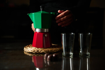 Barista preparing coffee with colorful moka pot and two glass cups