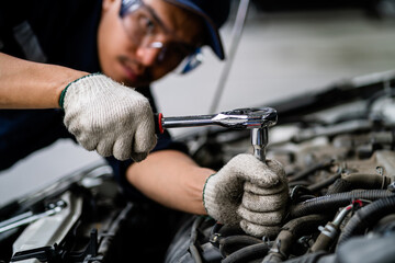Fototapete - A mechanic is working on a car engine. The mechanic is wearing a blue shirt and a blue hat