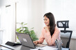 © Fahng - Confident businesswoman working on laptop at her workplace at modern office.Happy attractive asian business woman smiling working with laptop.