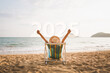 © Peera - New year 2025 holiday vacation concept Happy traveler asian woman relax and travel on chair beach in summer Thailand