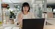 © peopleimages.com - Asian woman, wave or laptop with video call for virtual meeting, discussion or conversation at office. Female person, consultant or employee talking on computer for webinar or conference at workplace